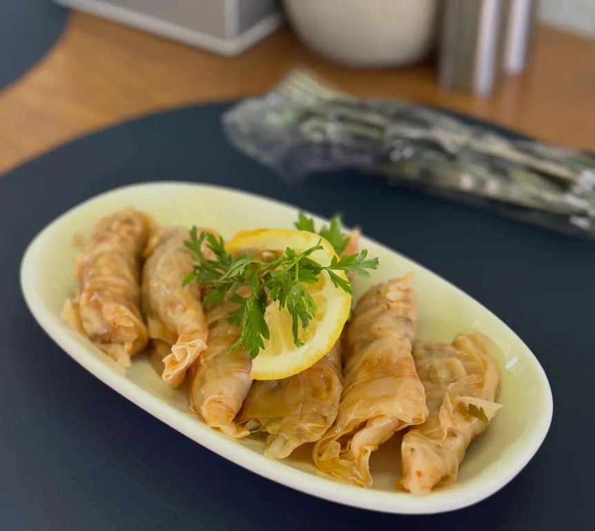 A plate of stuffed rolls served with lemon and parsley